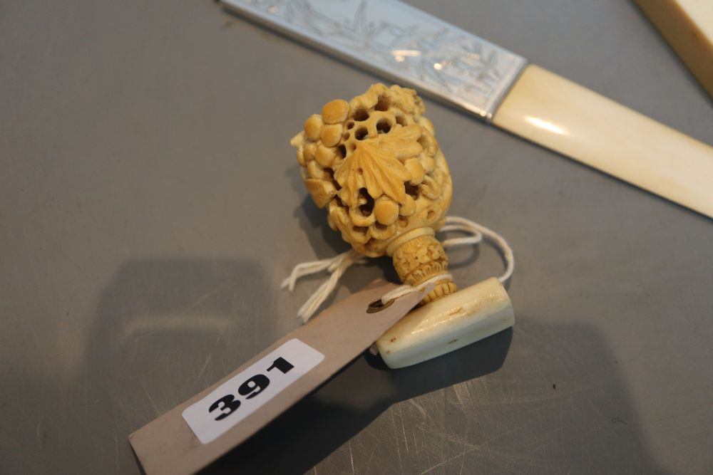 An ivory carving, an ivory seal and an ivory page turner, the handle marked sterling silver, all late 19th or early 20th century,